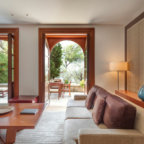 Sitting room at Aman Sveti Stefan with arched doorway opening onto a terrace.