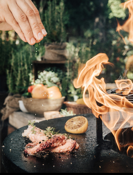 Hand pouring wine over grilled meat at Aman Sveti Stefan.