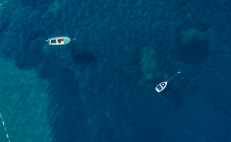 Aerial view of two boats on deep blue Adriatic waters at Aman Sveti Stefan.