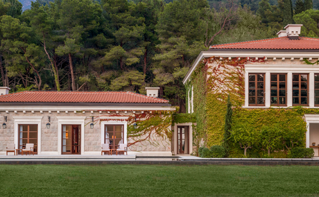 Wellness pavilion and main residence with terracotta roof at Aman Sveti Stefan, surrounded by green lawns and pine trees.