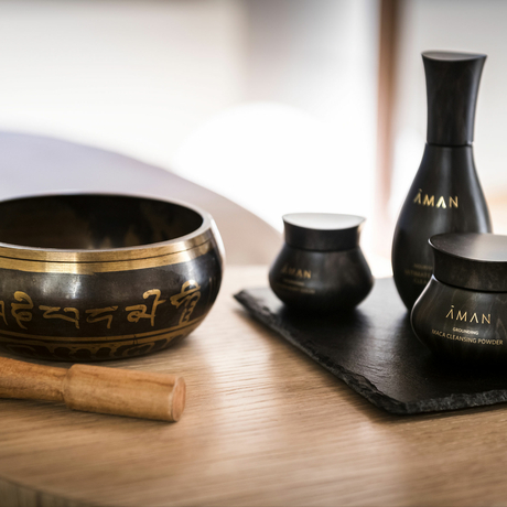Black spa products and wooden accessories arranged on a wooden surface at Aman Venice.