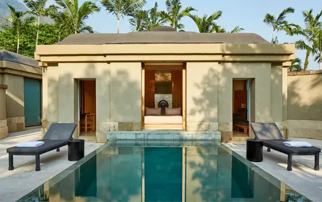 Spa pavilion with plunge pool at Amanjiwo, flanked by loungers beneath palm trees.