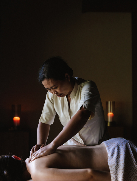 Therapist performing a healing treatment on a guest's foot at Amankila.