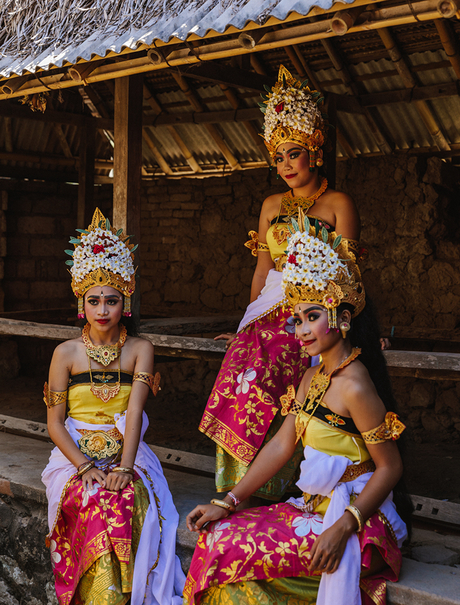 Balinese statues adorned with colourful flowers and traditional dress at Amankila.