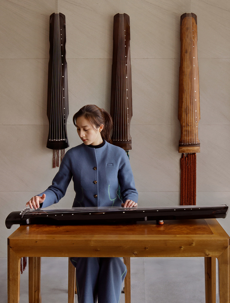Child playing guzheng, a traditional Chinese stringed instrument, at Amanyangyun.