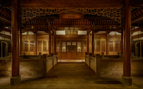 Illuminated traditional pavilion at Amanyangyun, with symmetrical wooden doors and warm lighting at dusk.