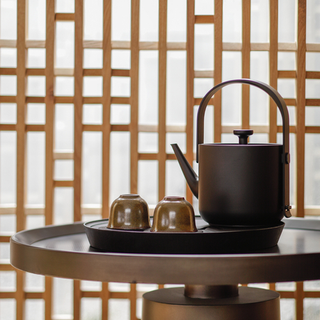 Tea service with black teapot and cups on round table at Amanyangyun.