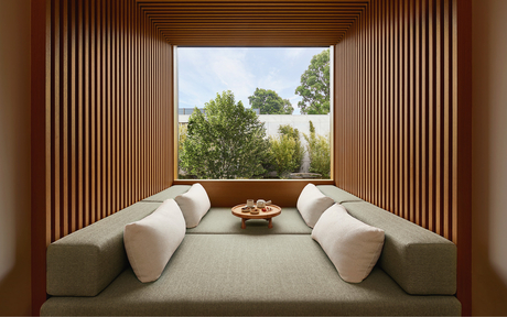 Two curved white chairs facing expansive windows overlooking gardens at Amanyangyun wellness retreat.