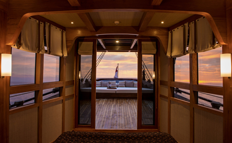 Stern bedroom view at Amandira with open double doors revealing ocean horizon at dusk.