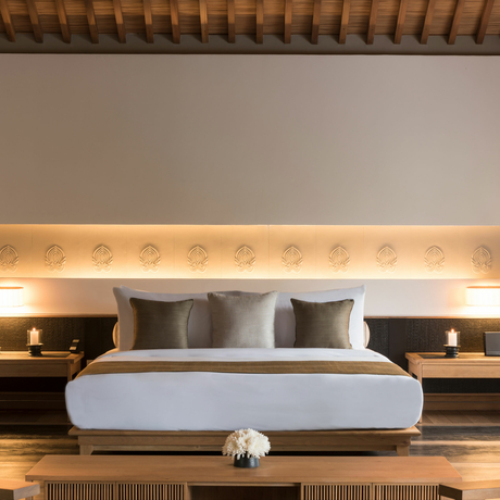 Principal bedroom at Amanoi with upholstered headboard and integrated lighting.