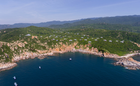 Aerial view of Amanoi's clifftop setting above turquoise waters and forested Vietnamese coastline.