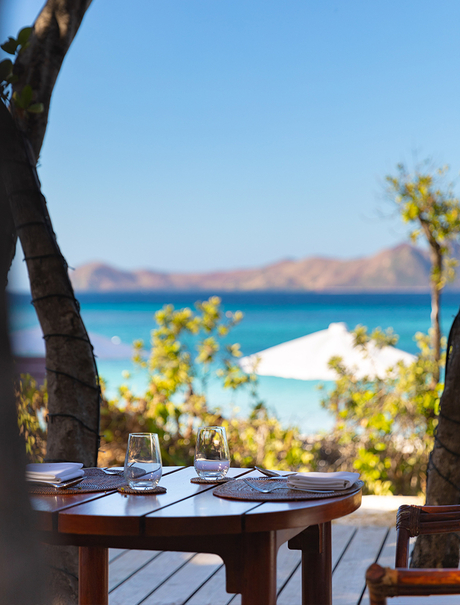 Dining table overlooking turquoise waters and white sand beach at Amanpulo.