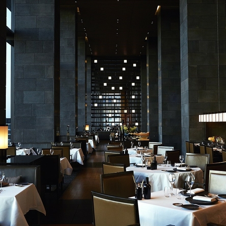 Dining venue at Aman Tokyo with soaring ceilings, floor-to-ceiling windows, and minimalist architectural design.