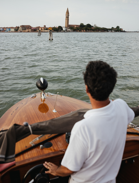 Captain at the helm of a private boat, steering towards the islands of Aman Venice.
