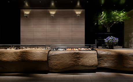 La Patisserie at Aman Tokyo, with natural wood counter seating and warm overhead lighting.