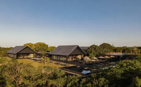 Amanemu resort main property nestled among trees with traditional architecture and water features in Japan.