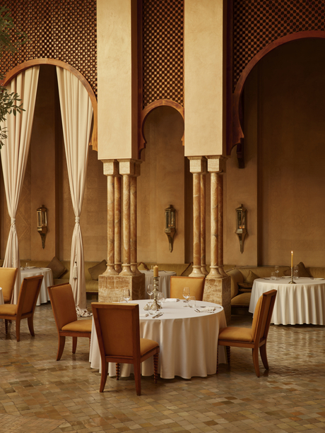 Moroccan restaurant at Amanjena with arched doorways, marble columns and intimate dining tables.