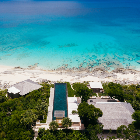 Aerial view of The Artist's Villa at Amanyara with turquoise waters and white sandy beach.
