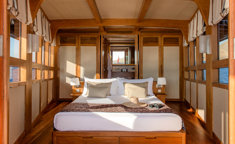 Principal cabin bedroom at Amandira with wooden interior and bed facing towards outdoor views.