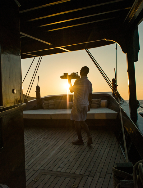 Silhouetted figure on the sundeck at Amandira during golden hour, overlooking the water.
