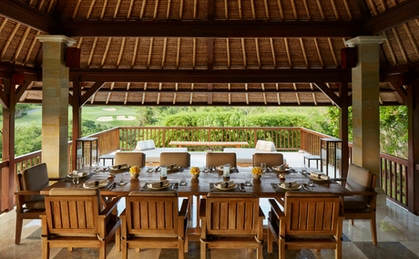 Dining pavilion at Aman Villas at Nusa Dua with wooden furnishings and garden views.