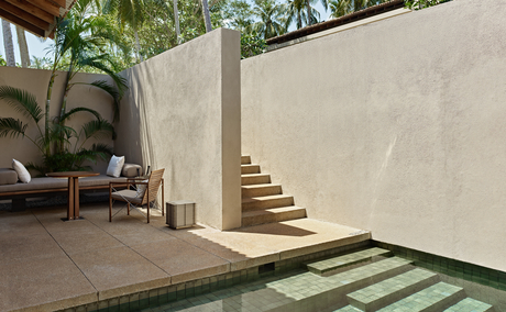 Amanwella suite courtyard with stone steps, planted urns, and minimalist walls in Sri Lanka.