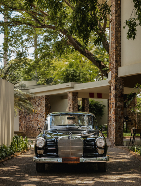Vintage car parked beneath a shaded pergola at Amansara, Cambodia.