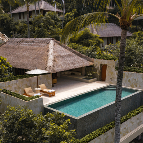 Infinity pool suite at Amankila with thatched-roof pavilion overlooking terraced gardens.