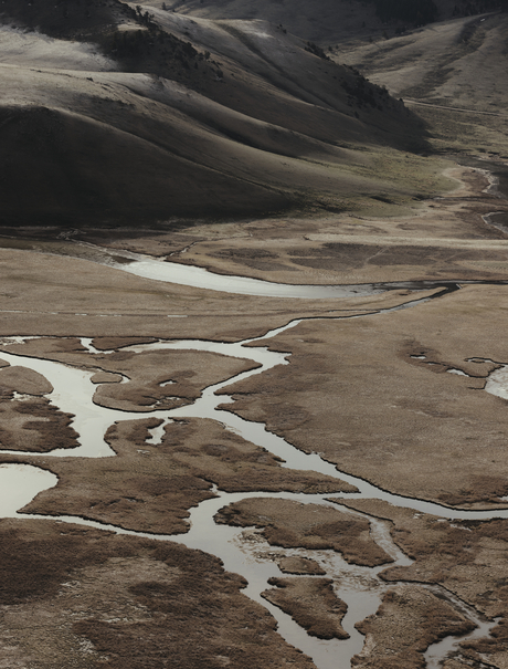 Winding river through arid mountains near Amangani, Wyoming, USA.