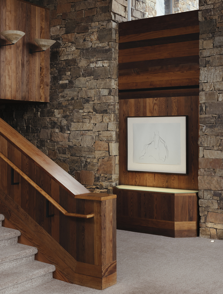 Grand staircase with wooden handrail and stone walls at Amangani, USA.