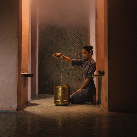 Woman receiving a spa treatment in a serene doorway at Amanjena, Morocco.