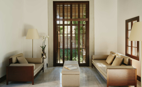 Deluxe sea view pavilion entrance at Amanruya, Turkey, with cream walls, wooden doors and warm furnishings.