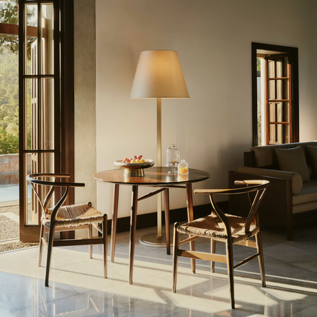 Living room in a Garden View Pavilion at Amanruya, featuring wooden furniture and warm lighting.