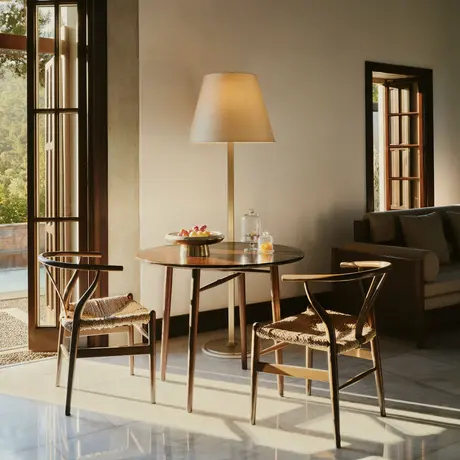 Living room in a Garden View Pavilion at Amanruya, featuring wooden furniture and warm lighting.