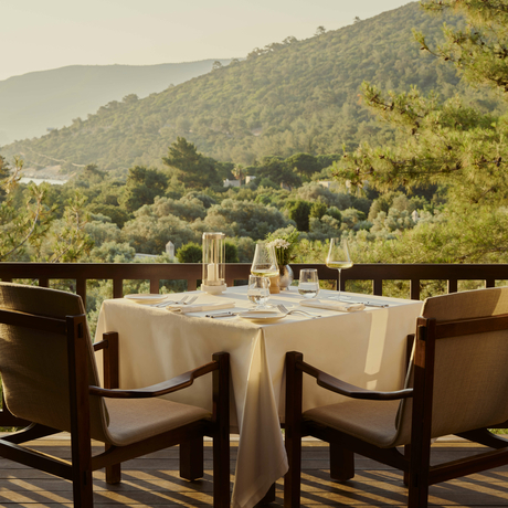 Private dining table set for wine tasting at Amanruya, Turkey, with mountain views.