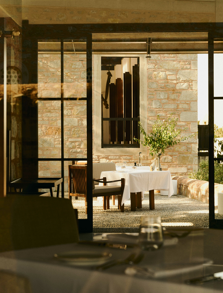 Amanruya dining venue with stone walls, large windows and contemporary furnishings.