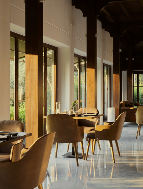 Sushi restaurant at Amanruya with wooden chairs, illuminated windows and polished stone flooring.