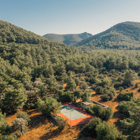 Aerial view of Amanyura tennis court nestled amongst forested hillside.