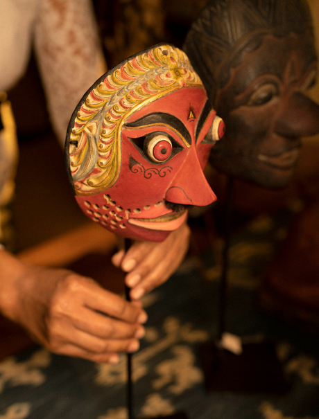 Ornate wooden mask with carved features and golden patina, displayed at Amandari in Ubud, Bali.