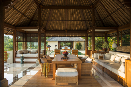 Amandari's open-sided pavilion with thatch roof, wooden furnishings, and garden views.