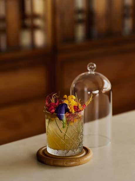 Colourful cocktail under glass cloche at Amanera's bar in Dominican Republic.