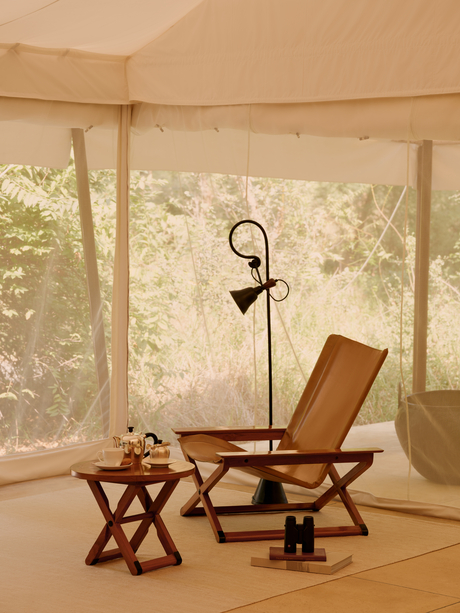 Tent interior at Aman-i-Khas with wooden furniture and canvas walls overlooking the landscape.
