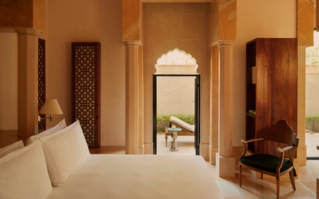 Courtyard Haveli Suite at Amanbagh with bed, archway, and traditional Indian architectural details.