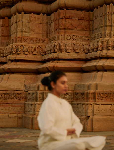 Woman practising yoga at Bhangarh Fort temple ruins, Amanbagh.