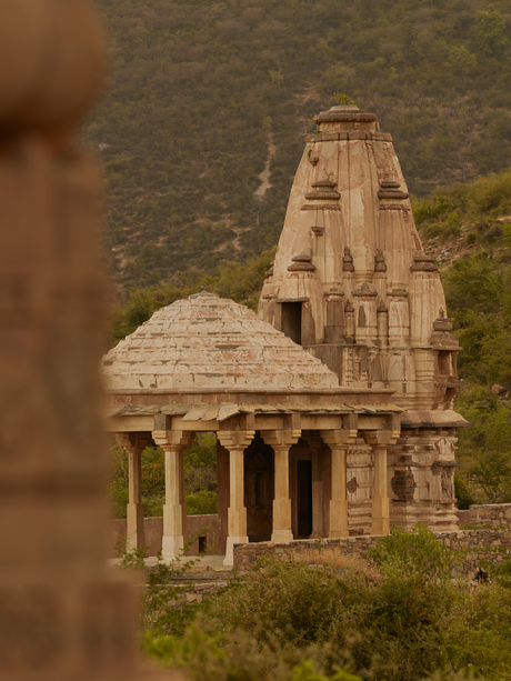 Historic cenotaph at Amanbagh, viewed through architectural detail with domed pavilion and ornate columns.