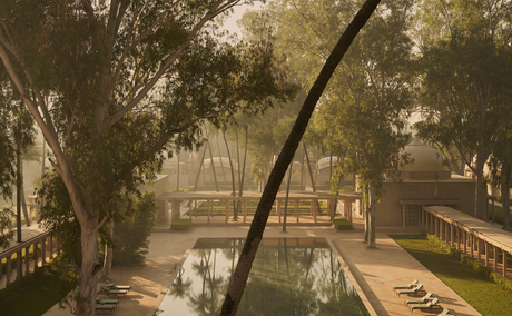 Courtyard view at Amanbagh with curved tree branch framing gardens and water features below.