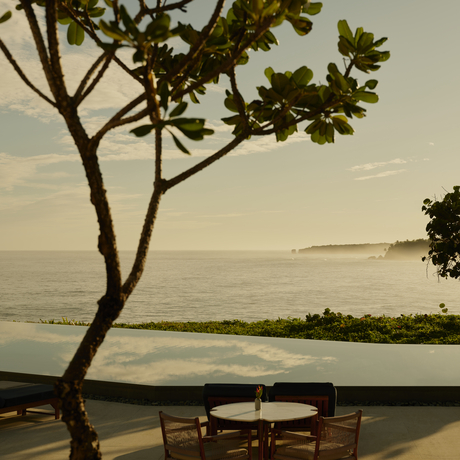 Coastal view at Amanera resort with a solitary tree framing the horizon and seating area below.