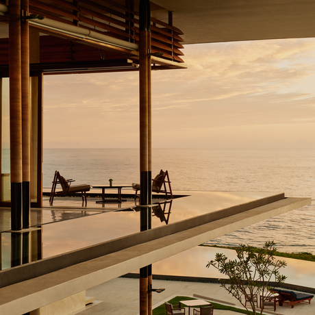 Amanera lounge bar with open doors framing a desert landscape at sunset.