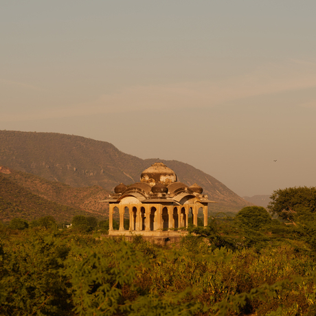 Neoclassical pavilion illuminated at dusk in the Aravalli hills at Amanbagh.
