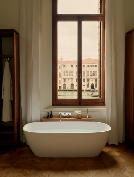 Freestanding bathtub positioned before a window overlooking the Grand Canal at Aman Venice.